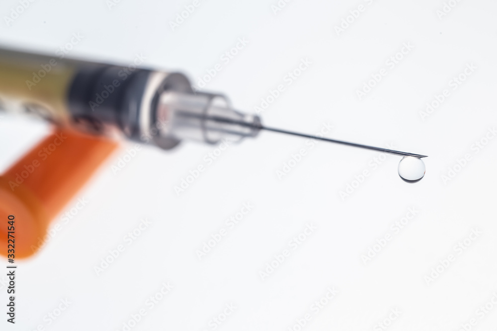 Insulin syringe needle with a drop on a white background. Insulin syringe needle with a drop on a white background.