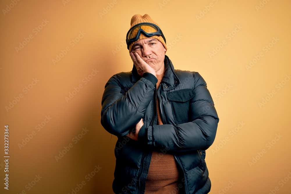 Middle age handsome grey-haired skier man on vacation wearing ski goggles thinking looking tired and bored with depression problems with crossed arms. Middle age handsome grey-haired skier man on vacation wearing ski goggles thinking looking tired and bored with depression problems with crossed arms.