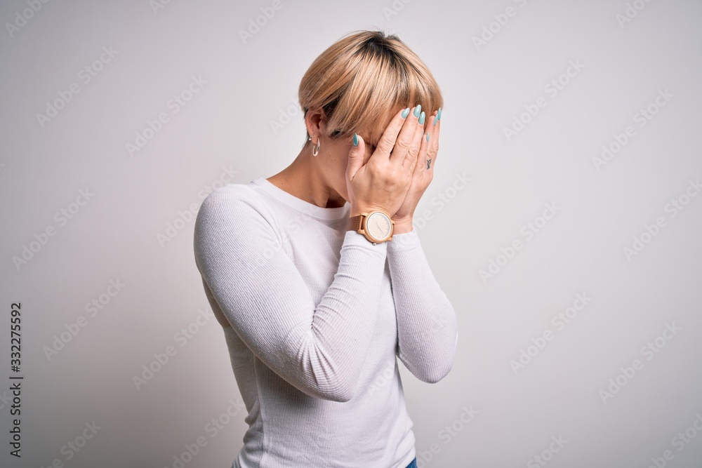 Young beautiful blonde woman with modern short hair hairstyle standing over isolated background with sad expression covering face with hands while crying. Depression concept. Young beautiful blonde woman with modern short hair hairstyle standing over isolated background with sad expression covering face with hands while crying. Depression concept.