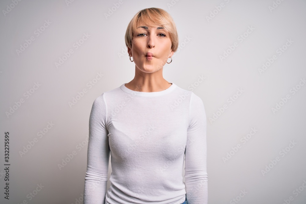 Young beautiful blonde woman with modern short hair hairstyle standing over isolated background making fish face with lips, crazy and comical gesture. Funny expression. Young beautiful blonde woman with modern short hair hairstyle standing over isolated background making fish face with lips, crazy and comical gesture. Funny expression.
