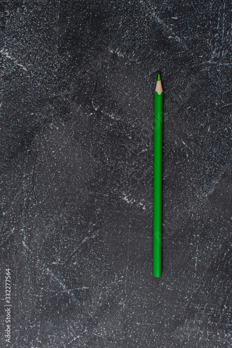 Green pencil on a black stone table