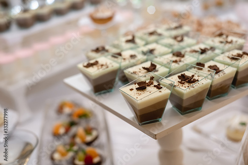 Sweet table for birthday or wedding ceremony. Candy bar with a lot of different candies and sweet cakes. Selective focus. Party and holiday celebration concept