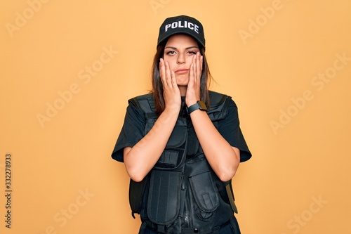 Young beautiful brunette policewoman wearing police uniform bulletproof and cap Tired hands covering face, depression and sadness, upset and irritated for problem
