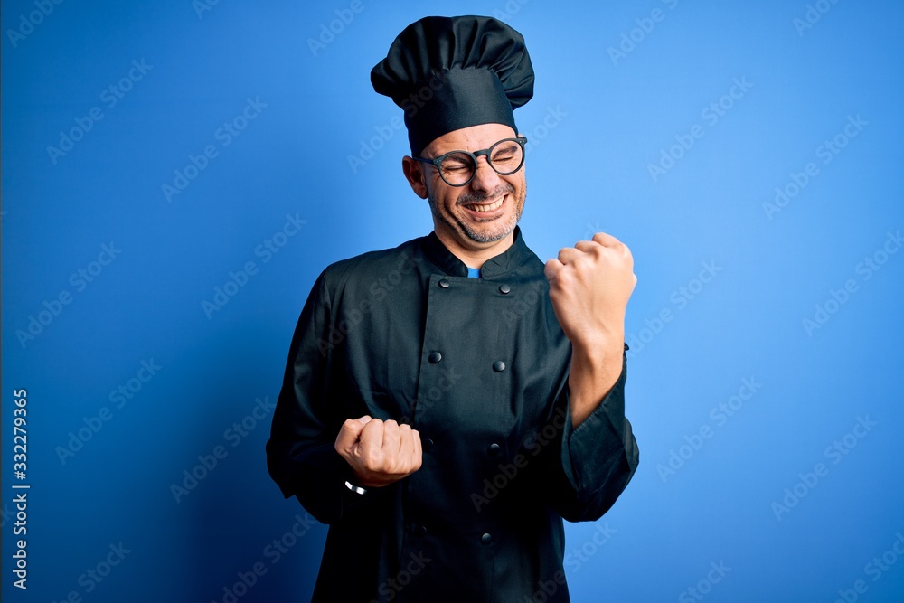 Young handsome chef man wearing cooker uniform and hat over isolated blue background celebrating surprised and amazed for success with arms raised and eyes closed. Winner concept. Young handsome chef man wearing cooker uniform and hat over isolated blue background celebrating surprised and amazed for success with arms raised and eyes closed. Winner concept.