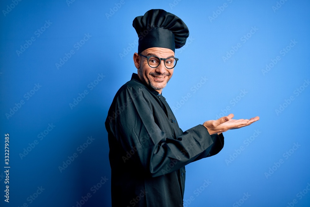 Young handsome chef man wearing cooker uniform and hat over isolated blue background pointing aside with hands open palms showing copy space, presenting advertisement smiling excited happy Young handsome chef man wearing cooker uniform and hat over isolated blue background pointing aside with hands open palms showing copy space, presenting advertisement smiling excited happy