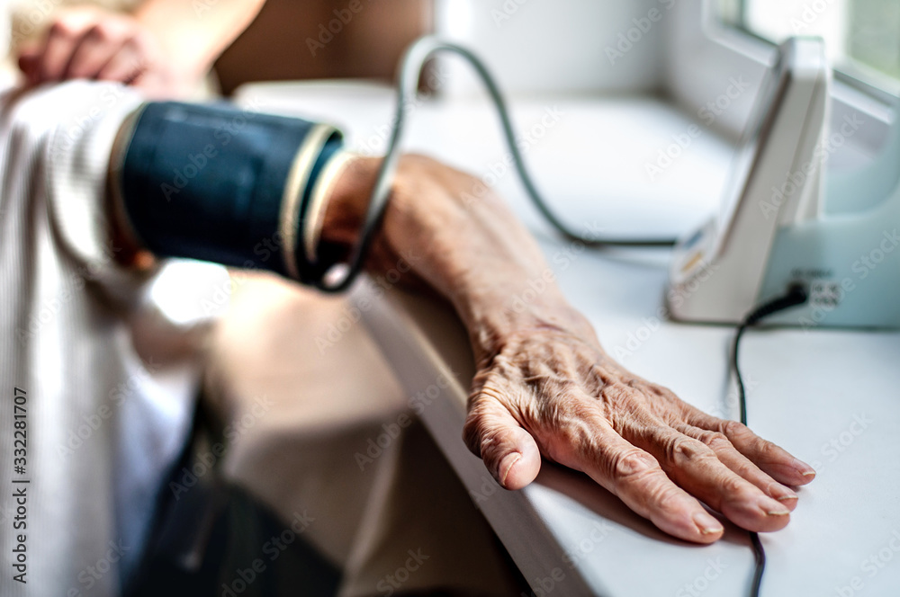 Hand of an elderly woman for 90 years. Blood pressure measurement. Hypertension at risk for coronavirus. Old people die from COVID-19. Grandma's wrinkled hand