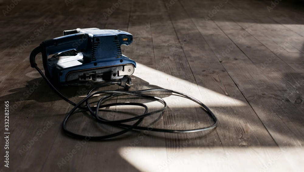 A machine for grinding wood on a wooden floor. Repairs.