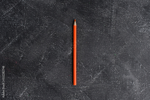 Orange pencil on a black stone table © Evgeny