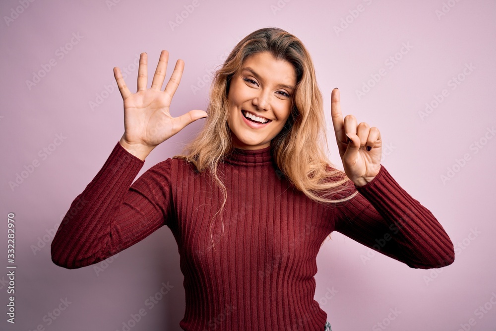 Young beautiful blonde woman wearing casual sweater over isolated pink background showing and pointing up with fingers number six while smiling confident and happy. Young beautiful blonde woman wearing casual sweater over isolated pink background showing and pointing up with fingers number six while smiling confident and happy.