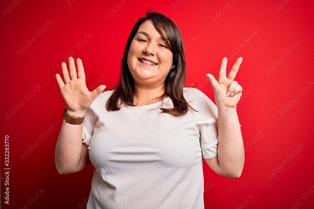Beautiful brunette plus size woman wearing casual t-shirt over isolated red background showing and pointing up with fingers number eight while smiling confident and happy. Beautiful brunette plus size woman wearing casual t-shirt over isolated red background showing and pointing up with fingers number eight while smiling confident and happy.