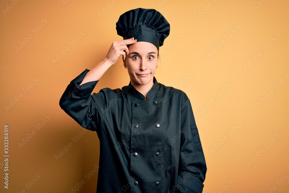 Young beautiful chef woman wearing cooker uniform and hat standing over yellow background worried and stressed about a problem with hand on forehead, nervous and anxious for crisis Young beautiful chef woman wearing cooker uniform and hat standing over yellow background worried and stressed about a problem with hand on forehead, nervous and anxious for crisis