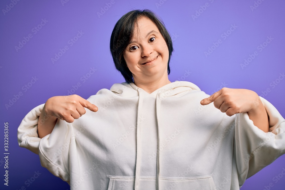 Young down syndrome sports woman wearing fitness sweatshirt over purple background looking confident with smile on face, pointing oneself with fingers proud and happy. Young down syndrome sports woman wearing fitness sweatshirt over purple background looking confident with smile on face, pointing oneself with fingers proud and happy.