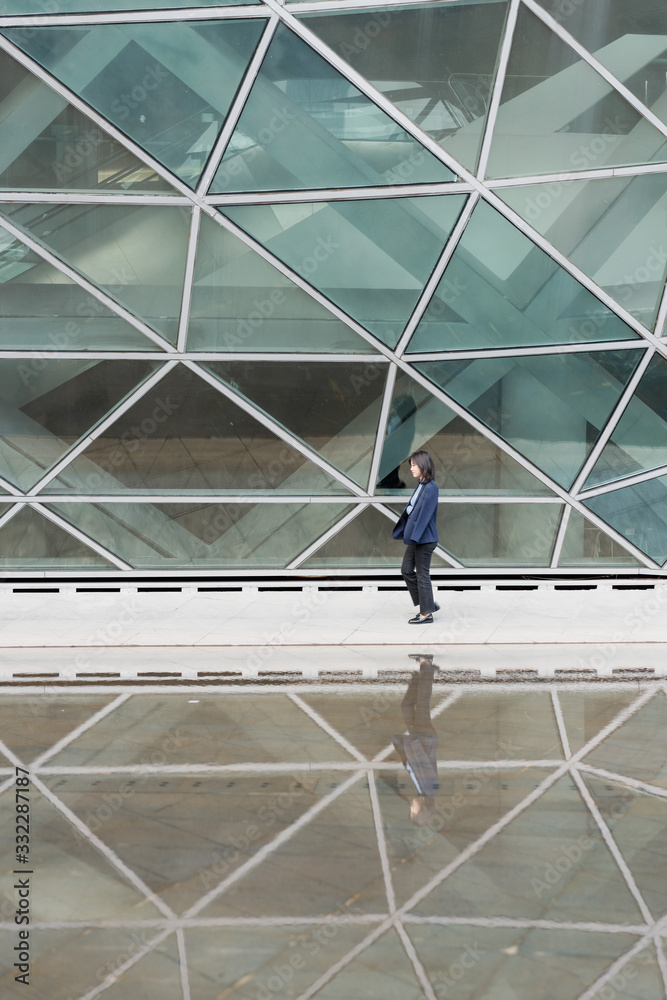 Young business women passing through glass buildings