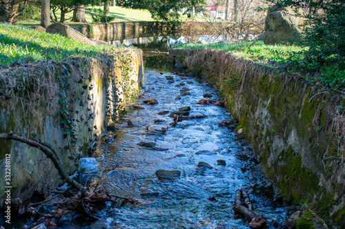 A Man Made Stream With Cobblestone Walls on Each Side