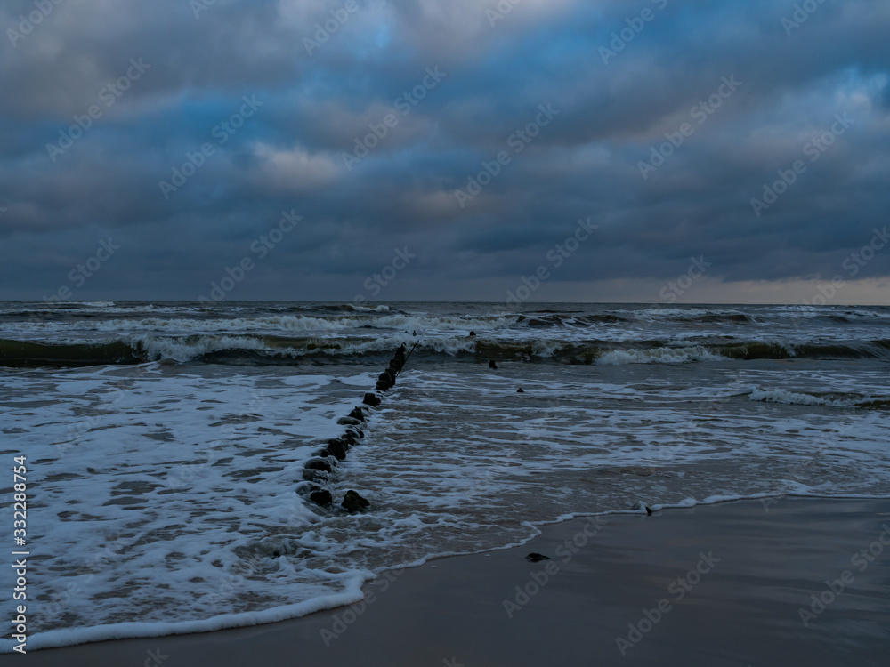Fototapeta premium After the sunrise at the estuary of the Piasnica River, Poland, Debki beach. Remains of the pier.