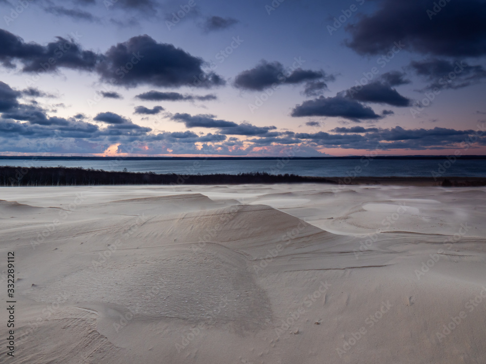 Obraz premium Sunrise on the moving dunes during windy morning. Leba, Poland.