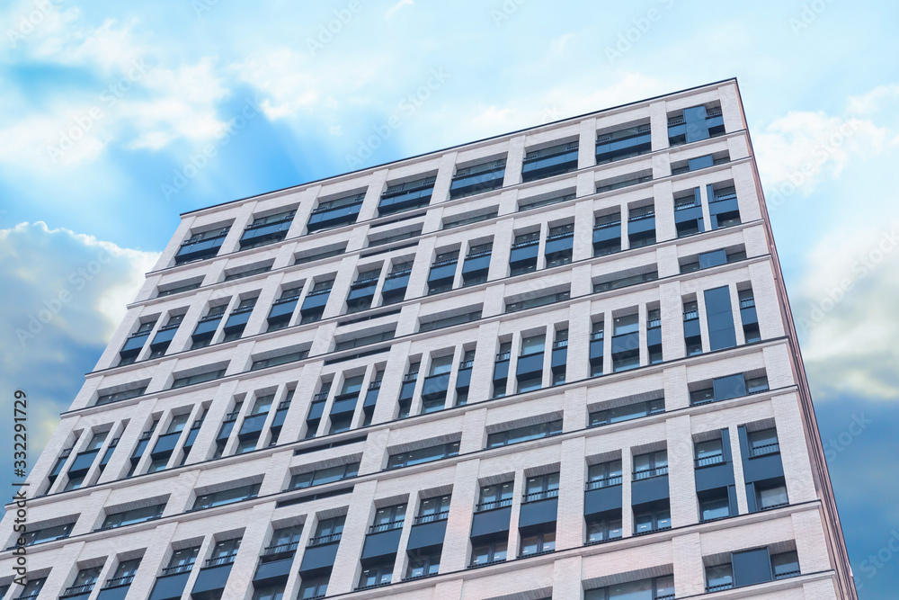 tall building new white windows focus bottom up background sky blue