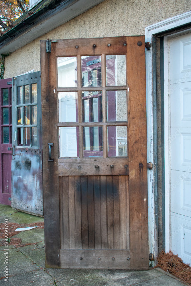 An Old Brown Wooden Door With Windows Attached to a Garage