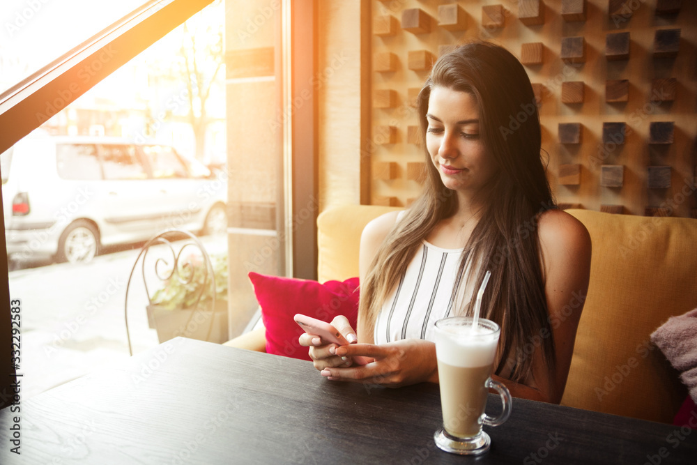 Young pretty woman blogger in cafe in city centre with smartphone Young pretty woman blogger in cafe in city centre with smartphone