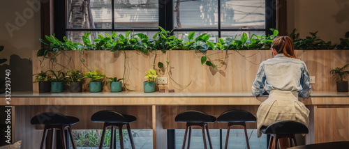 panoramics perspective view of businesswoman working alone at counter bar in coffee shop and coworking space photo