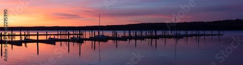 Marina Dock Panorama at Dawn with Sun Rising to a Pink and Purple Clouded Sky Over a Calm Tree Lined River