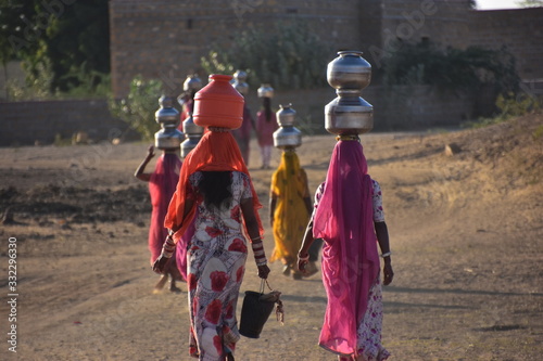 インドのラジャスタン州
ジャイサルメールのクーリー村
水瓶を頭に乗せて運ぶ、沢山の女性達
民族衣装のサリーを着て運ぶ、美しい姿 photo