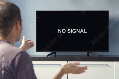 Poor digital TV signal. No signal inscription on the TV screen. The guy is upset about TV breaking down.