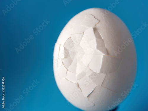 macro photo of a broken white egg on a blue background
