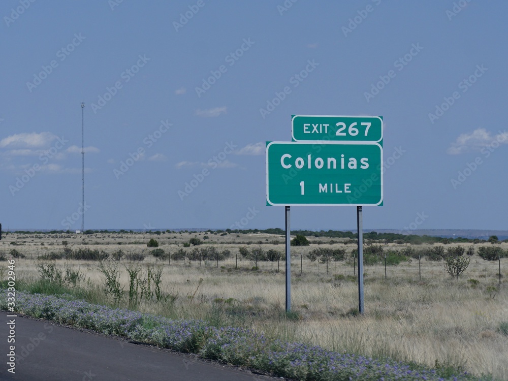 Directional sign on the road with directions to the exit for Colonias in New Mexico. Directional sign on the road with directions to the exit for Colonias in New Mexico.