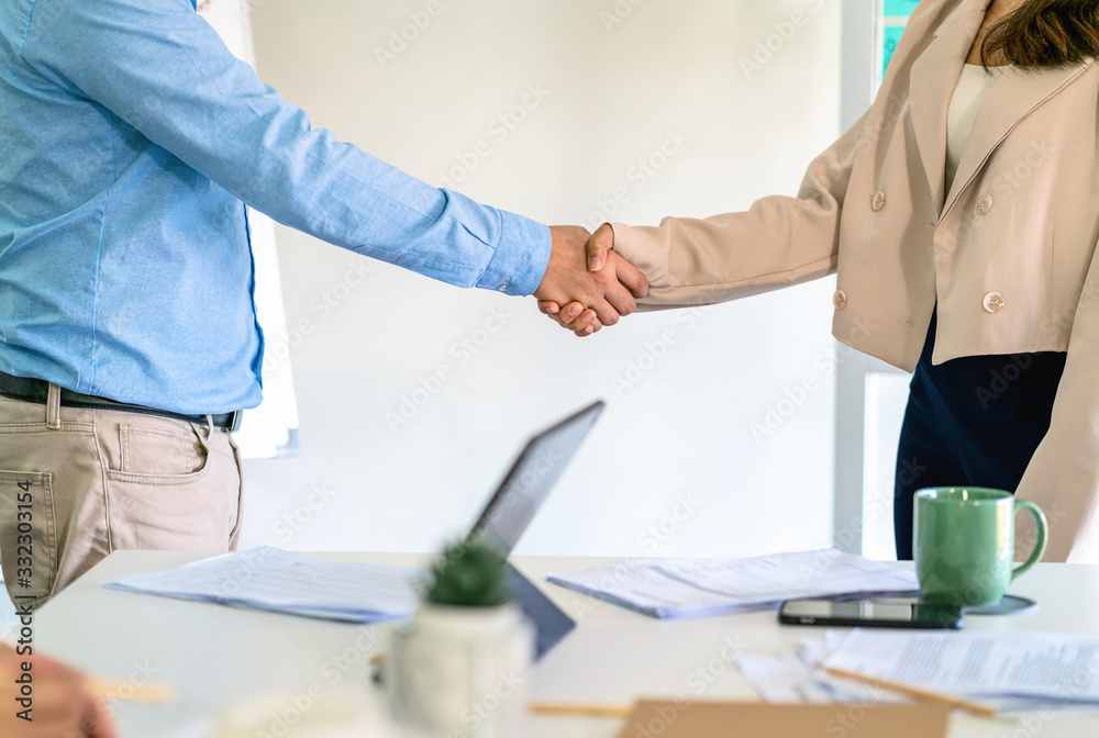 Closeup handshake of asian partner businessman and businesswoman in modern office after deal the agreement together, business Negotiate and accomplishment, Small business owner and stockholder concept Closeup handshake of asian partner businessman and businesswoman in modern office after deal the agreement together, business Negotiate and accomplishment, Small business owner and stockholder concept