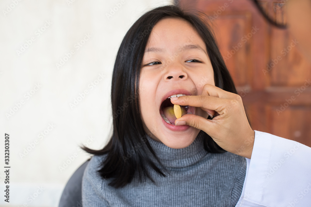 cute little girl having sick and happy to taking medicine in mouth. .Kid having pharmaceutical medical dose for pain relief or antibiotic medication curing from illness. healthcare,medicine concept . cute little girl having sick and happy to taking medicine in mouth. .Kid having pharmaceutical medical dose for pain relief or antibiotic medication curing from illness. healthcare,medicine concept .