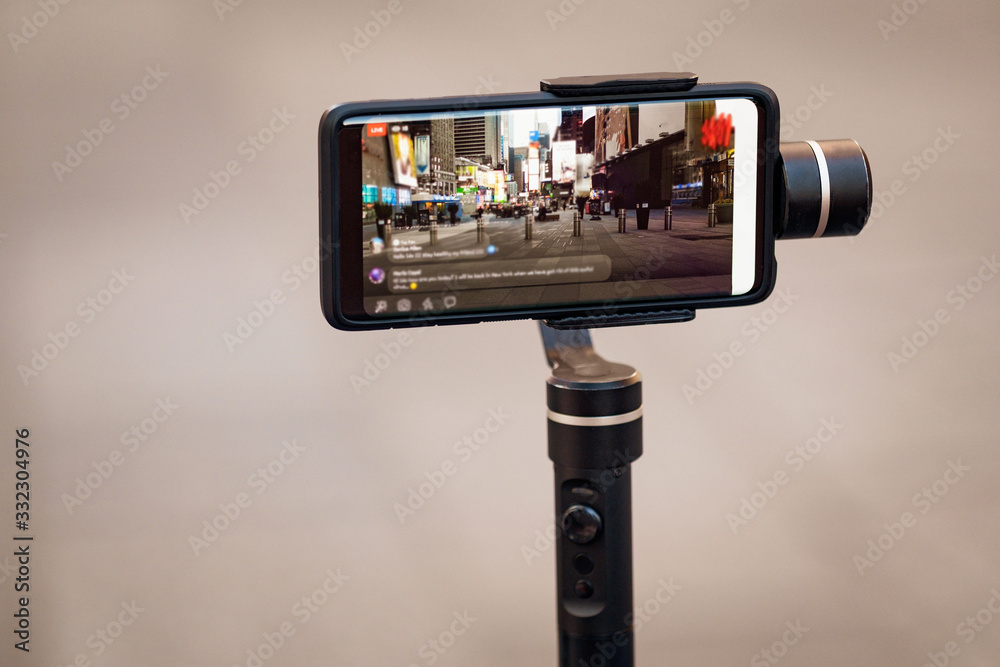 Phone with stabilizer, tripod, gimbal. Taking pictures and live video in New York city. Vlog, video blogging, street photography concept. Copyspace Phone with stabilizer, tripod, gimbal. Taking pictures and live video in New York city. Vlog, video blogging, street photography concept. Copyspace