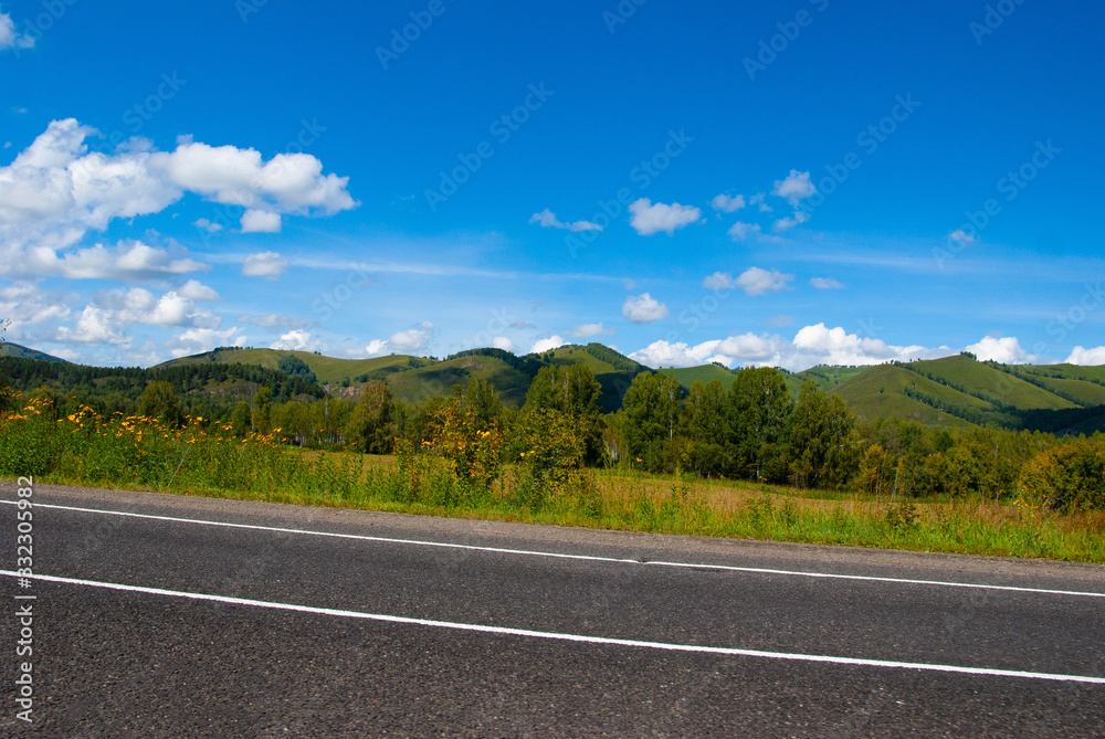Fototapeta premium asphalt road and green hills on horizon