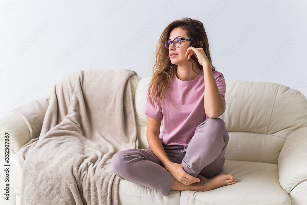 Young attractive woman dressed in beautiful colorful pajama posing as a model in her living room. Comfortable sleepwear, home relaxation and female fashion concept.