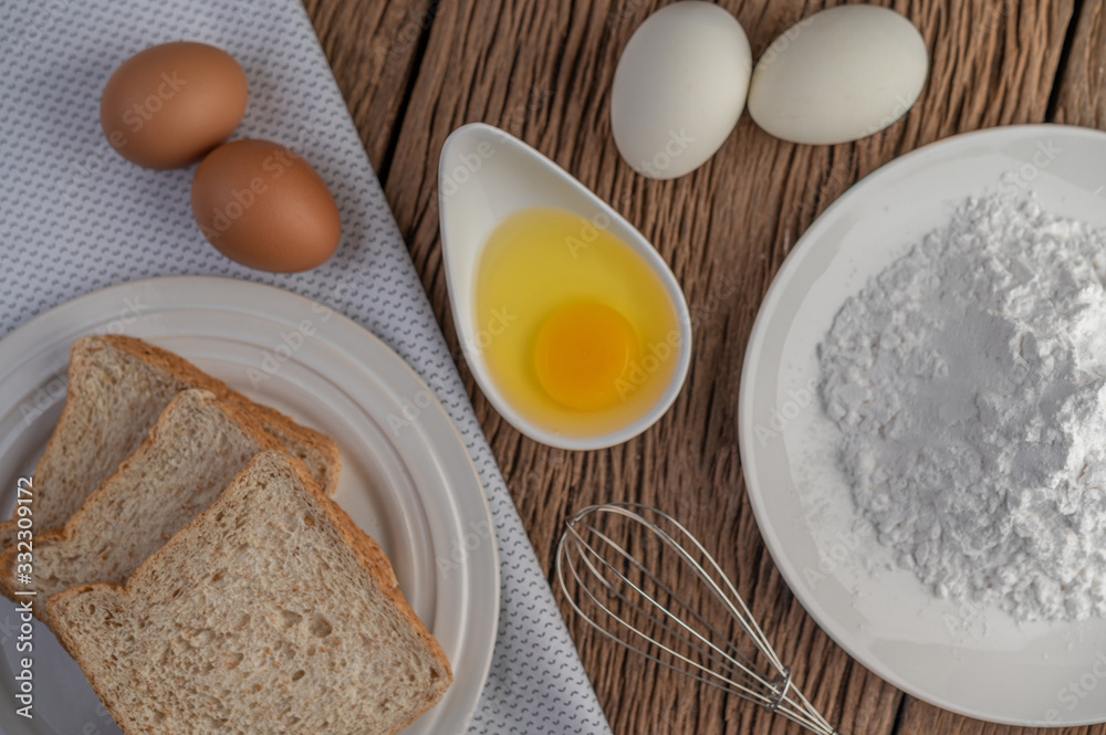 Eggs, bread, tapioca flour and an egg beater, ingredients used in bakery Eggs, bread, tapioca flour and an egg beater, ingredients used in bakery