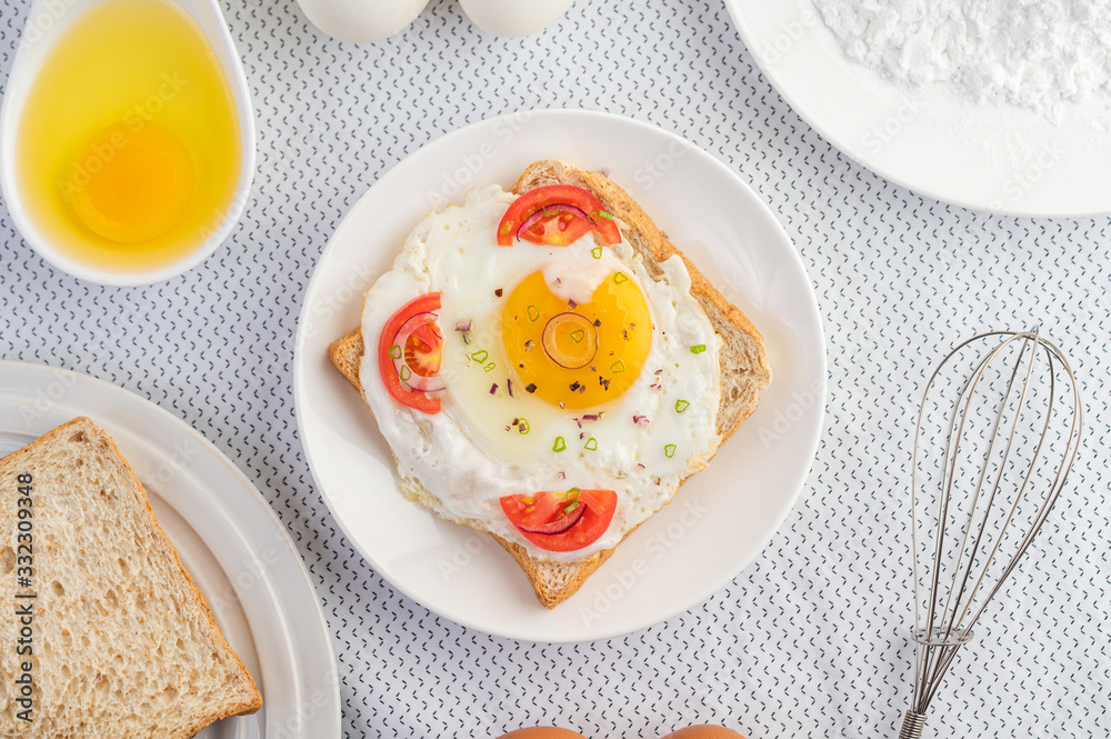 Bread placed with a fried egg with tomatoes, tapioca flour and sliced spring onions. Bread placed with a fried egg with tomatoes, tapioca flour and sliced spring onions.