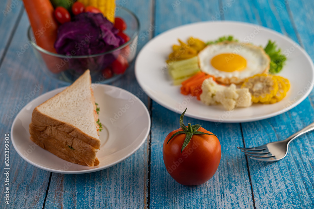 American breakfast on a white background with fried egg, salad, pumpkin, cucumber, carrot, corn, cauliflower, tomato and sandwich American breakfast on a white background with fried egg, salad, pumpkin, cucumber, carrot, corn, cauliflower, tomato and sandwich