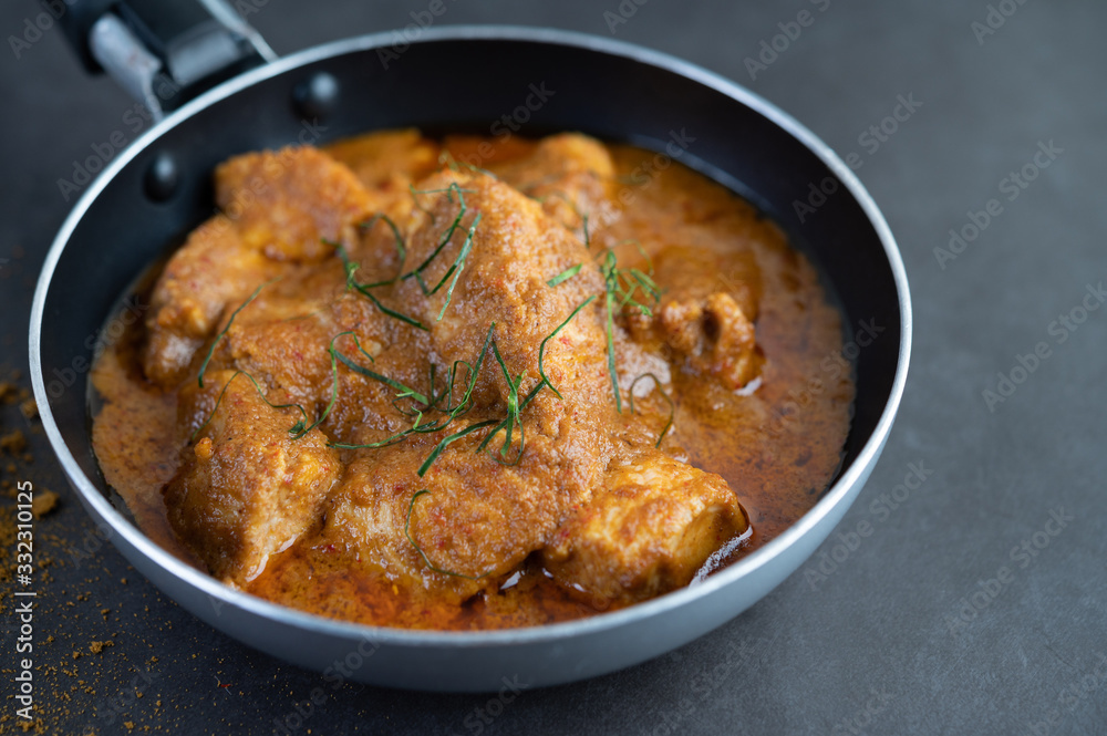 Massaman curry in a frying pan with spices on the cement floor Massaman curry in a frying pan with spices on the cement floor