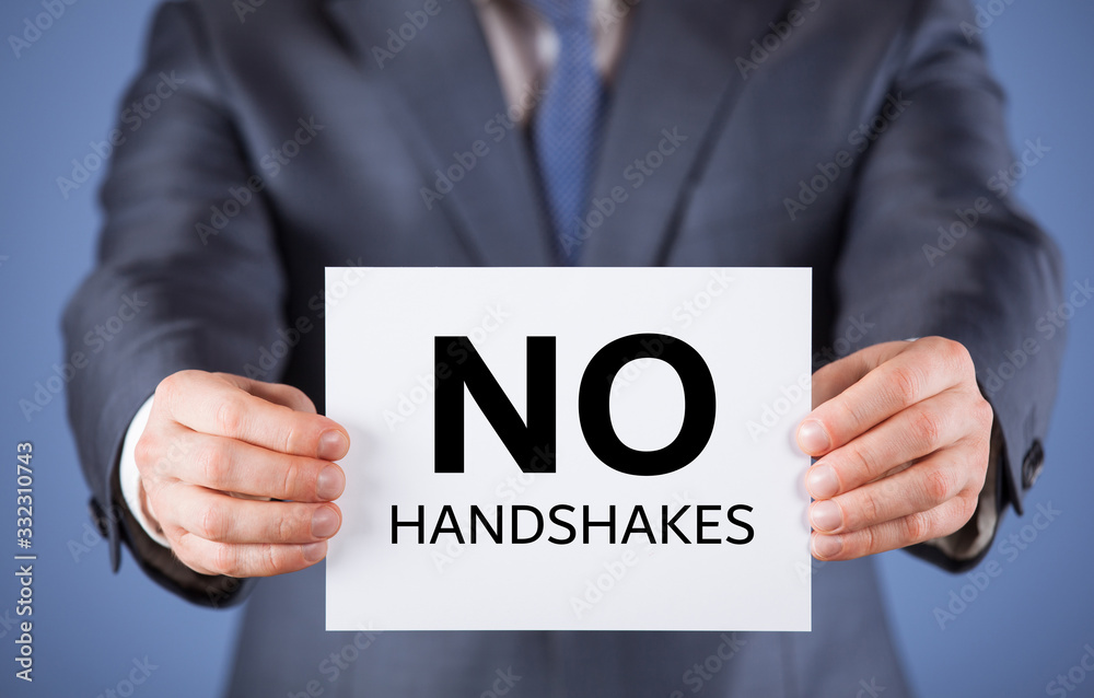 Unrecognizable businessman demonstrates a reminder to avoid handshakes Unrecognizable businessman demonstrates a reminder to avoid handshakes