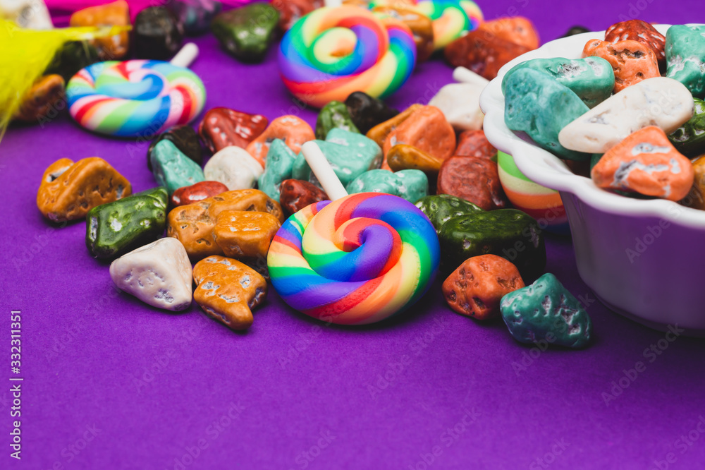 Lollipops and candy pebbles. sweets in the form of colored stones. colored background with colorful candies