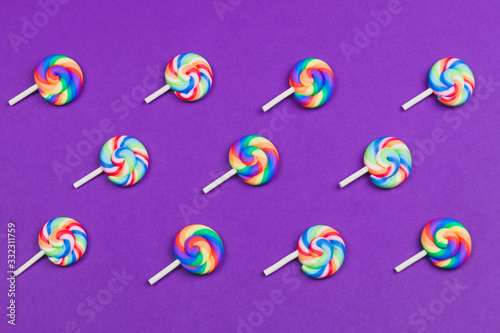 Lollipops are arranged symmetrically on a colored background. colorful candies