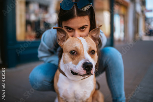 Fototapeta Naklejka Na Ścianę i Meble -  A young beautiful girl behind her brown dog. Portrait of a dog