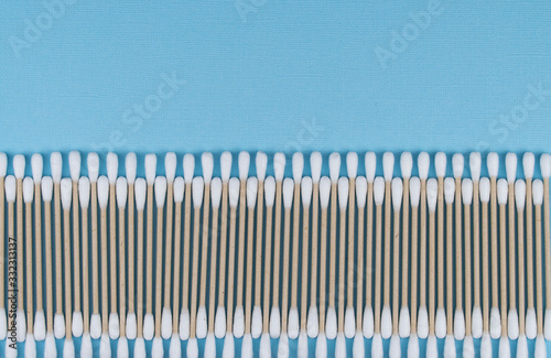 Flat lay composition with cotton swabs on blue background. natural cotton sticks made from cotton and cane.