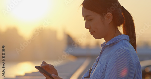 Photography Woman use of smart phone under sunset in Hong Kong