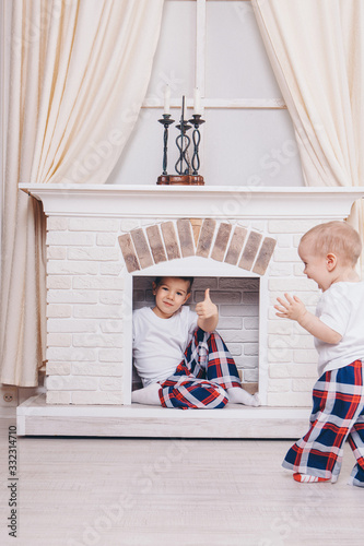 the concept of a healthy lifestyle , child protection, home interior - these are teenagers playing together. Happy children: brothersa by the fireplace photo