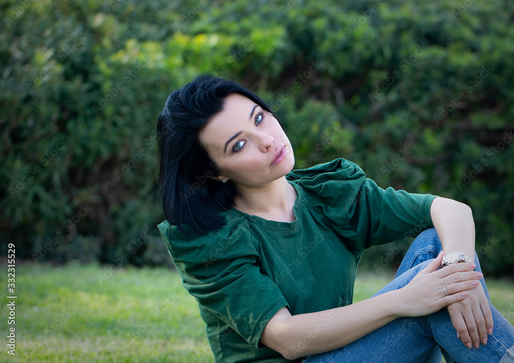 Beautiful girl enjoying nature outdoors in a park. The girl laughs and rejoices, a positive emotion. Beautiful girl enjoying nature outdoors in a park. The girl laughs and rejoices, a positive emotion.