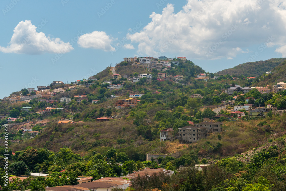 a village filled with houses populates a hill on a bright sunny day