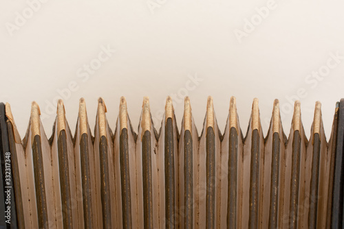 detail of old accordion bellows on wooden table in vintage tone, close up. music concept