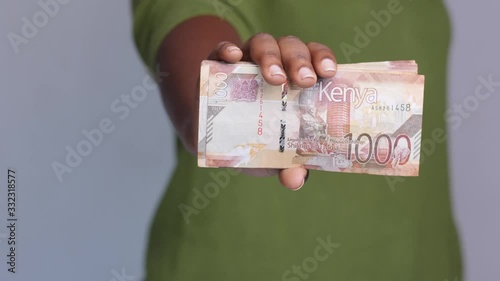 Close up shot of female hand revealing  Kenyan shillings money cash. photo