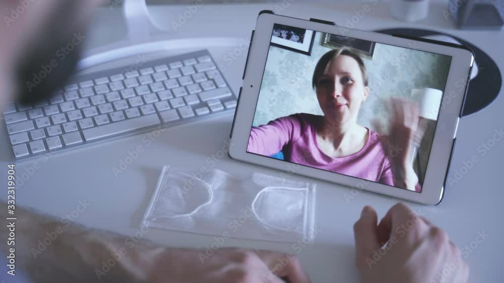 man talking with friend via video call on table spbas waving hand. facetime with wife, girlfriend while coronavirus covid19 2020 epidemic quarantine. medical mask. safety concept man talking with friend via video call on table spbas waving hand. facetime with wife, girlfriend while coronavirus covid19 2020 epidemic quarantine. medical mask. safety concept